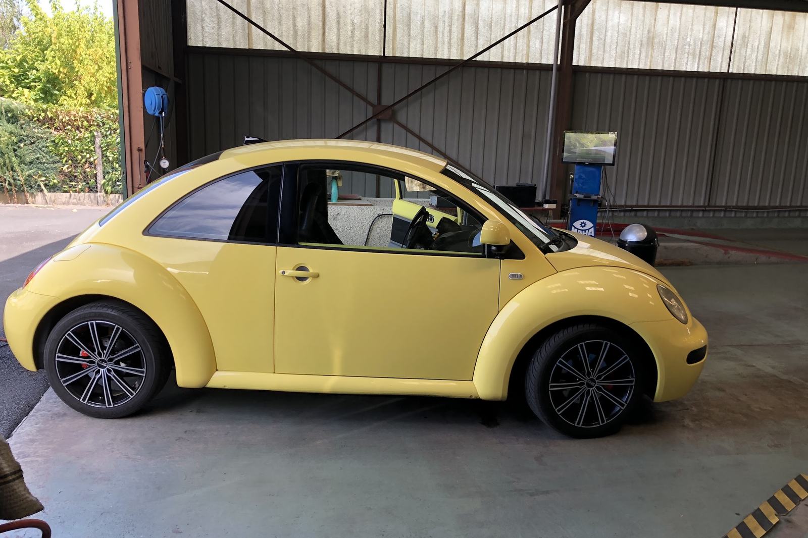 Une Volkswagen New Beetle jaune dans l’atelier
